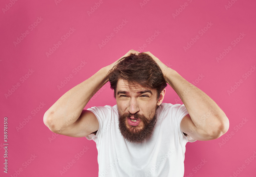 A man on a pink background gestures with his hands Copy Space irritability emotions A man on a pink background gestures with his hands Copy Space irritability emotions
