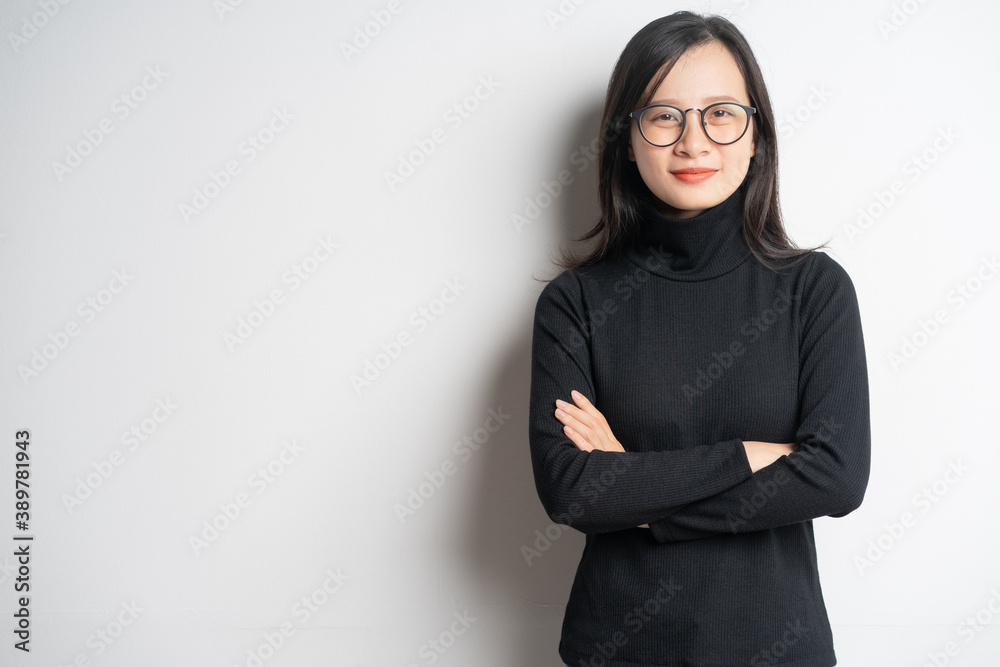 Portrait of a smiling asian businesswoman standing with crossed arms and wearing glasses Portrait of a smiling asian businesswoman standing with crossed arms and wearing glasses