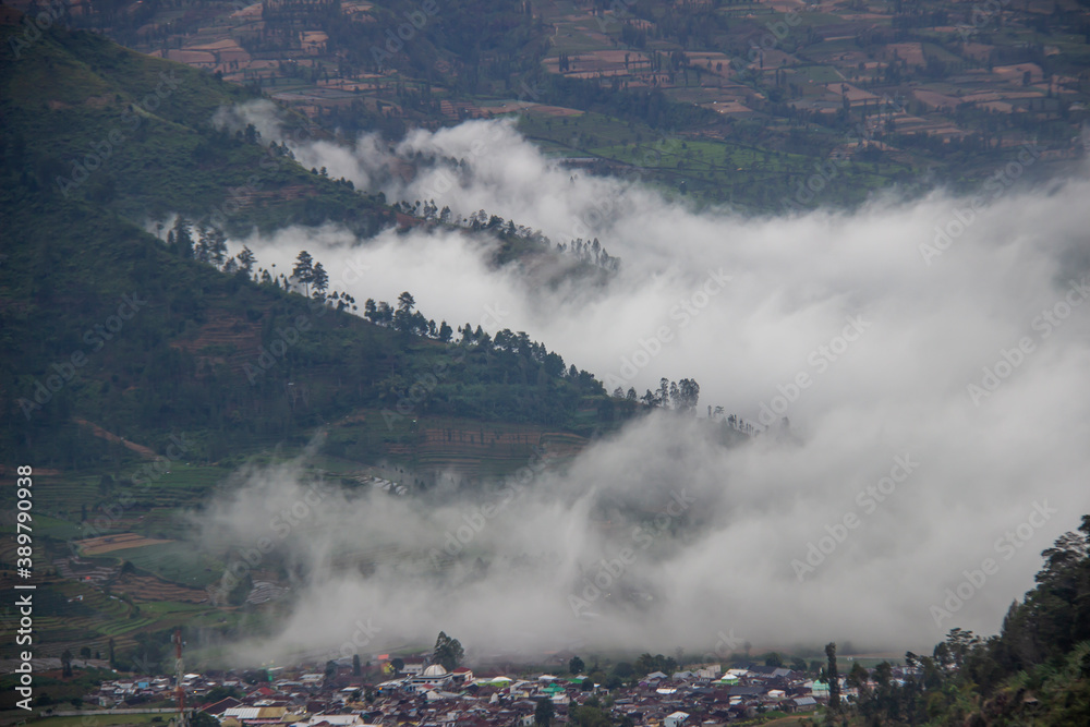 tourist destinations in the Dieng Plateau, Central Java. see rural scenery at the foot of the Sikunir mountains and Mount Sindoro and the hills decorated with a thin fog