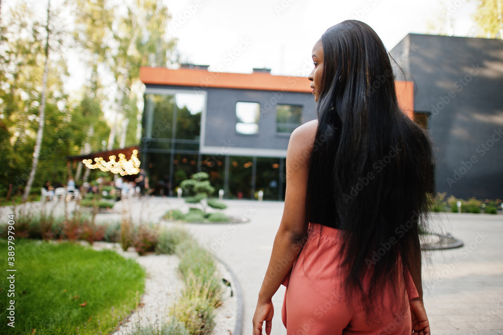 Φωτογραφία Fashionable african american woman in peach pants and black blouse pose outdoor