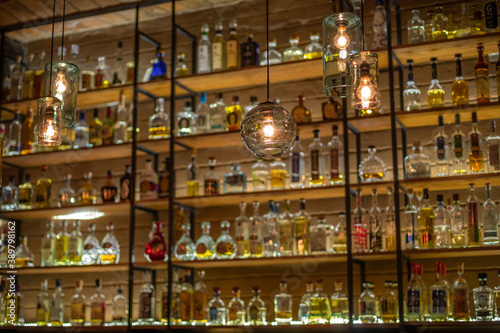 Defocused background of bar counter with various bottles of alcohol.