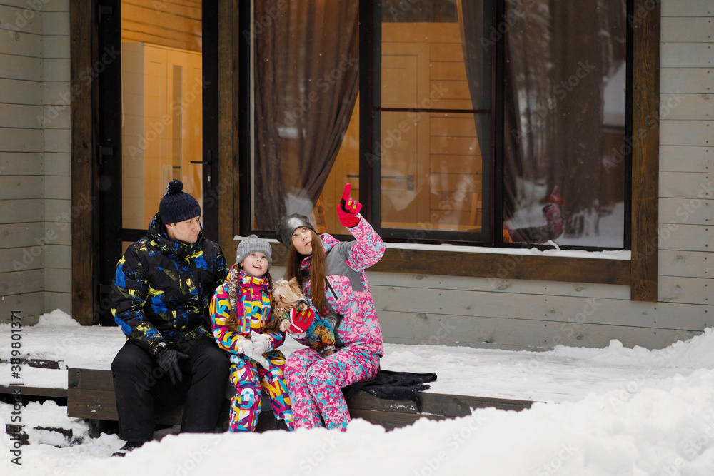 Naklejka premium Family in winter on the porch of the house