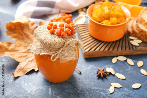 Jar of tasty pumpkin jam on table