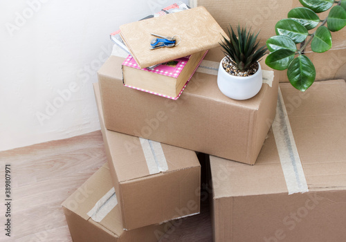 Foto full boxes of things with indoor flowers and keys to a new house, moving to anot