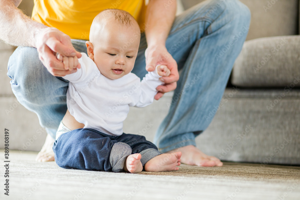 Happy father playing with adorable baby in the room at home. Happy father playing with adorable baby in the room at home.