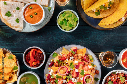 Mexican food background. Nachos  tacos  guacamole  tequila  quesadillas  overhead shot on a dark blue wooden table with a place for text