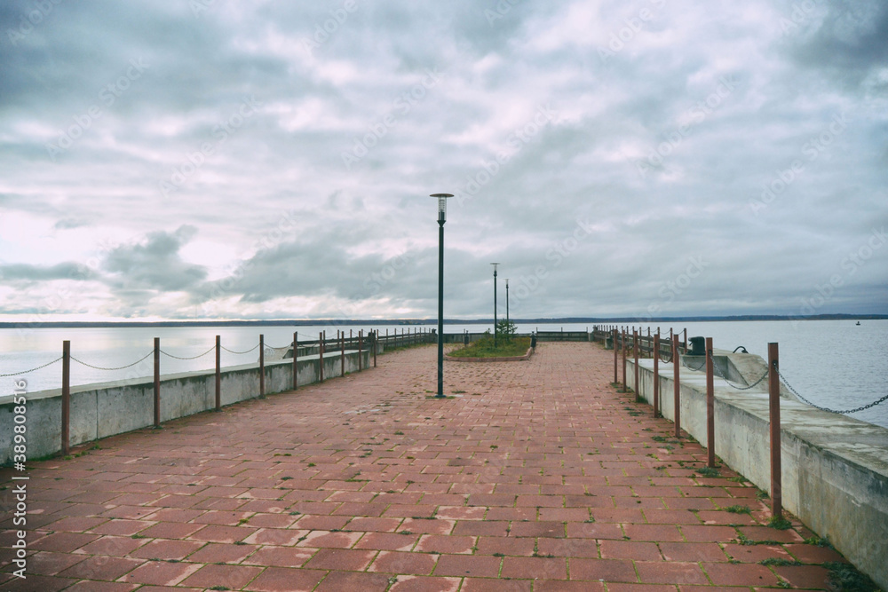 The pier overlooks the sea against the backdrop of a cloudy autumn sky.