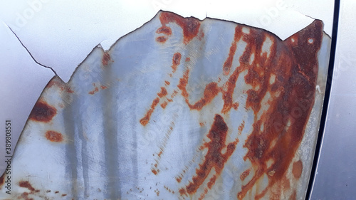 The surface of the car body paint that is cracked and peeled, causing many red rust spots