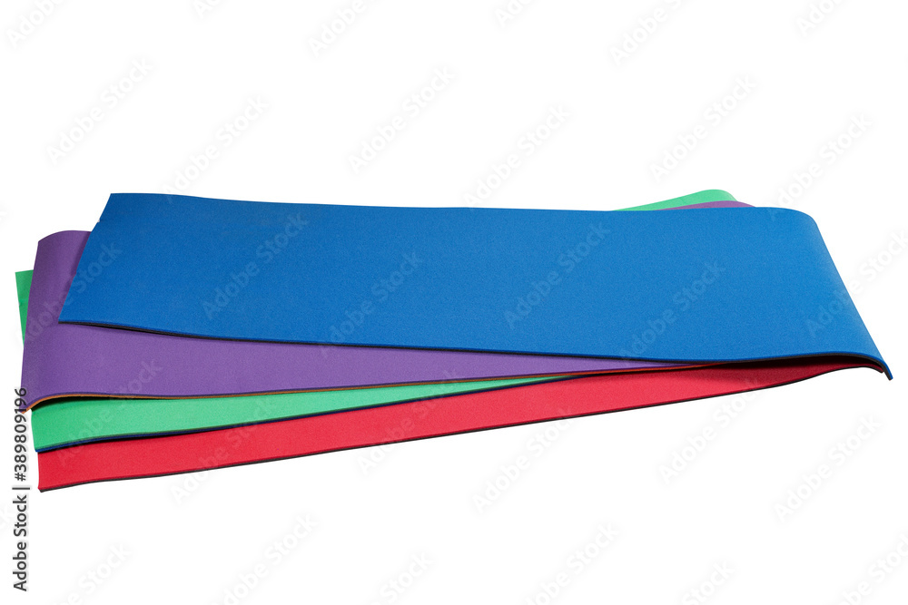 four colored fitness and yoga mats stacked one on top of the other, assortment showcase, white background