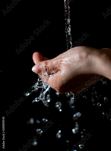 jets of water pouring into the palm on a black background