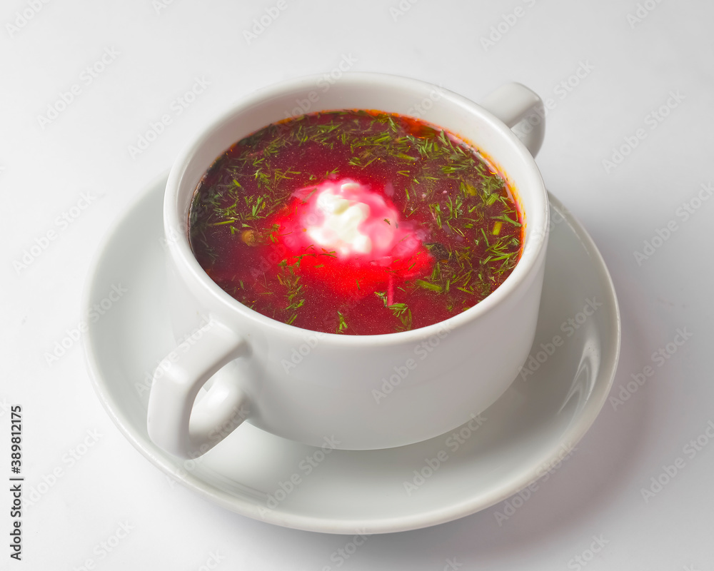 Ukrainian beetroot soup - borscht with sour cream served in a white bowl over white background. Ukrainian beetroot soup - borscht with sour cream served in a white bowl over white background.