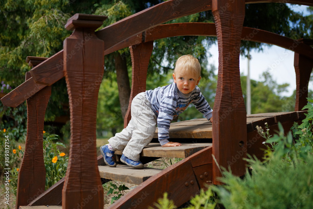 little child playing on a wooden ladder little child playing on a wooden ladder