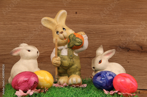 Photography Closeup shot of three easter bunnies figurines on a wooden background