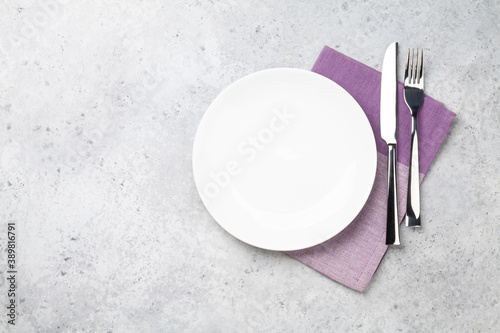 White empty plate, fork, knife and napkin