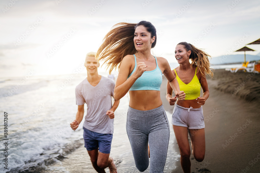Group of young friends running and exercising on the beach Group of young friends running and exercising on the beach
