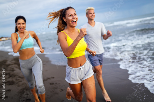 Group of sport people running on the beach