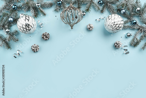 Christmas fir branches, white decoration, pine cones, confetti on blue holiday background. Merry Christmas and New Year greeting card, winter holiday. Flat lay, top view, Xmas banner