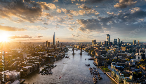 Wide panoramic view to the modern skyline of London, United Kingdom, along the Thames river during sunset time photo