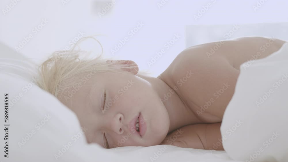Cute little girl is rolling in bed waking up after having fairy tale dreams Cute little girl is rolling in bed waking up after having fairy tale dreams