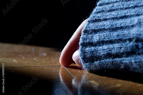 Photography Hand partially covered with a blue sleeve lying on a parquet floor