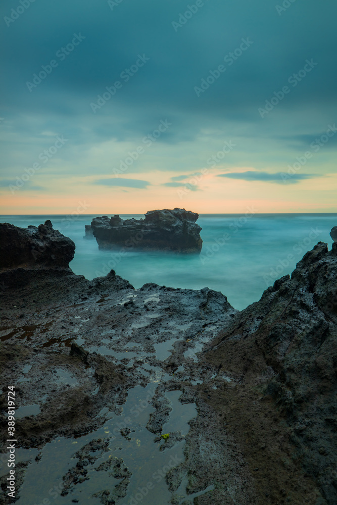Picturesque seascape. Amazing landscape. Rock in the ocean. Motion waves. Silky water. Long exposure image. Soft focus. Concept of nature background. Mengening beach, Bali