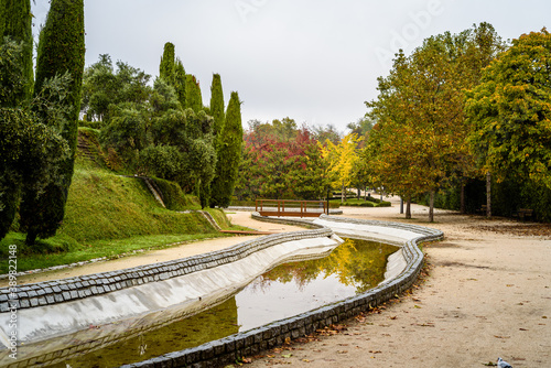 Scene of the Buen Retiro Park in Madrid during the fall with vibrant colors and the paths covered with fallen leaves