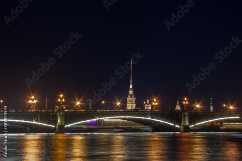 Illuminated bridge over the river at night. Blurry background photo. View of Saint Petersburg.