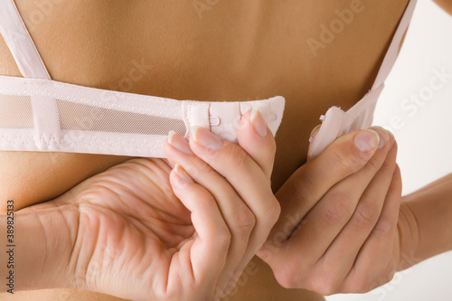 Картината върху платно Young adult woman hands putting on or taking off bra