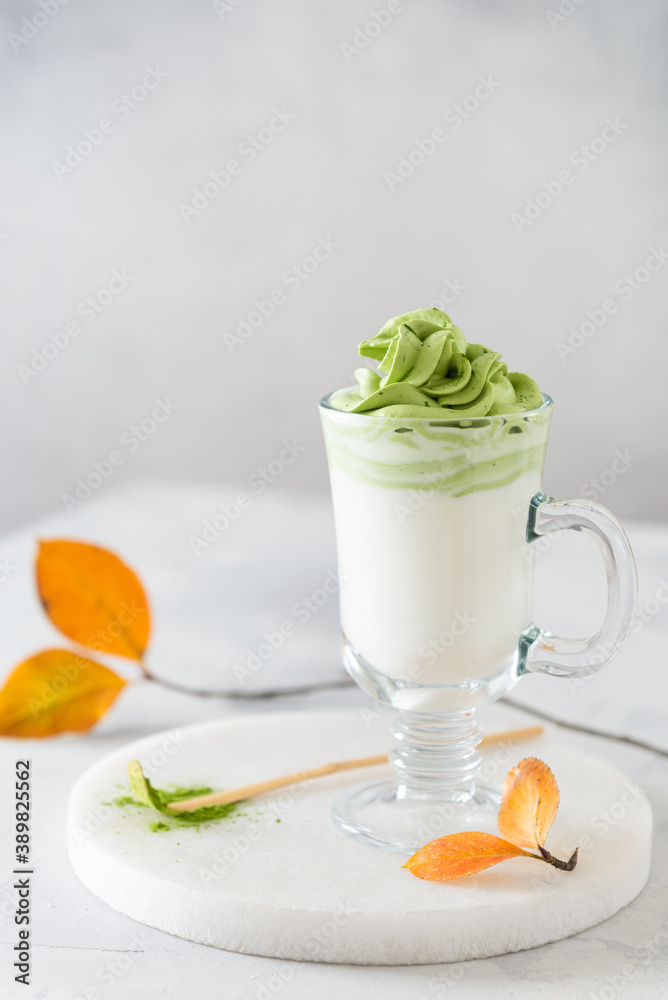 Green Matcha cappuccino with almond milk in a glass on light background. Side view, copy space. Super foods, matcha recipe, green spirulina, detox, healthy eating. Green Matcha cappuccino with almond milk in a glass on light background. Side view, copy space. Super foods, matcha recipe, green spirulina, detox, healthy eating.