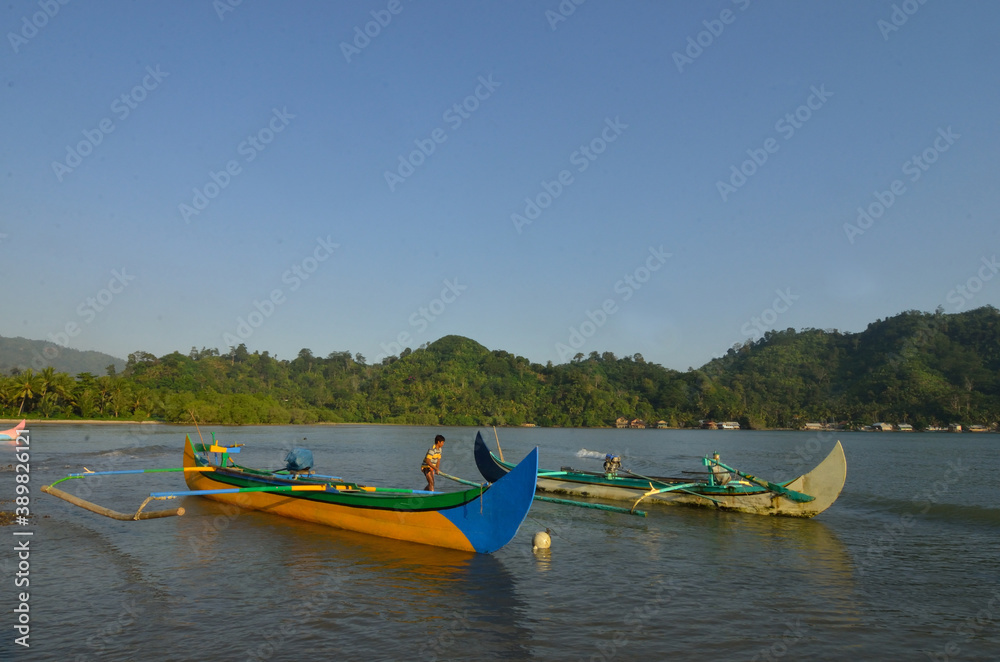 Fototapeta premium Indonesian fisherman on his outrigger boat at Kiluan Bay.