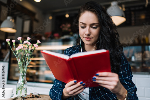 Pensive woman reading book in cafe