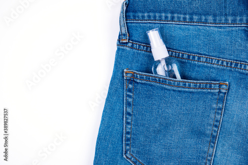 Top view of  antibacterial antiseptic spray for hands sanitizer in bottle in jeans pocket  isolated on  white background. Space for text.