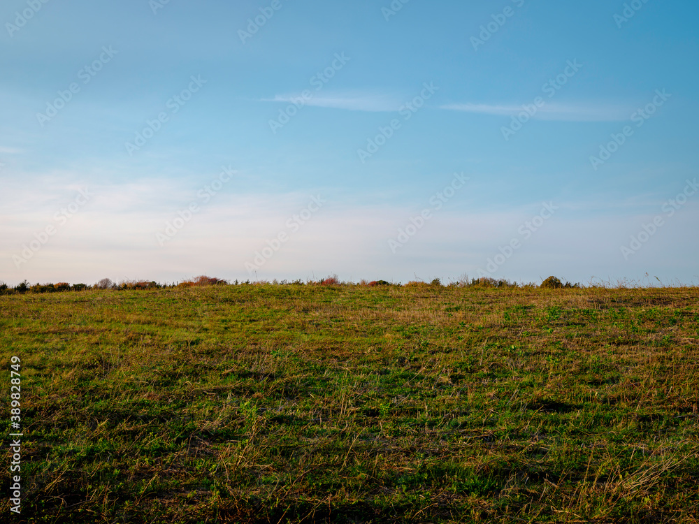 Hill landscape with green grasses on blue cloudy sky backgrounds