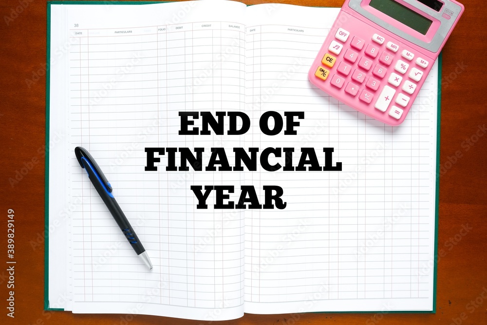 Flatlay picture of account manuscript book written End Of Financial Year with calculator and pen. Flatlay picture of account manuscript book written End Of Financial Year with calculator and pen.
