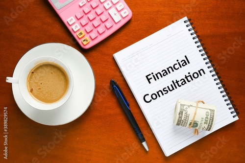 Flatlay picture of financial consultation at notebook, fake cash, calculator, pen and cup of coffee.