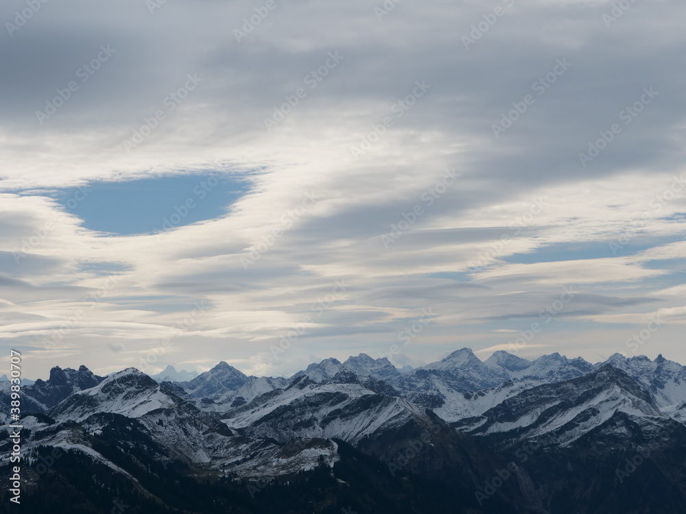 Panorama-Blick über die schneebedeckten Alpen in Tirol in Österreich bei guter Fernsicht und leicht bewölktem Himmel