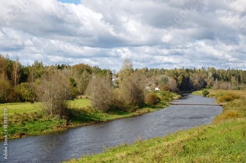 Rural landscape with a river among the fields on a sunny summer day.