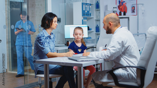 Pediatrician writing prescription for kid after examination. Healthcare practitioner, physician, specialist in medicine providing health care services consultation diagnostic treatment in hospital.