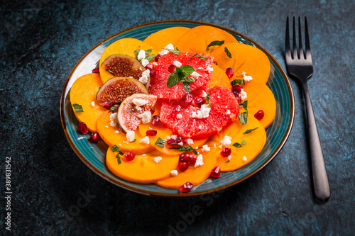 Persimmon carpaccio salad with pomegranate, feta cheese, pink grapefruit and figs