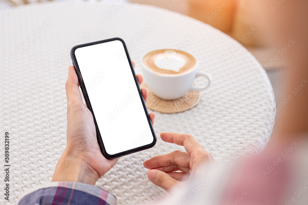 cell phone blank white screen mockup.woman hand holding texting using mobile on desk at coffee shop.background empty space for advertise.work people contact marketing business,technology