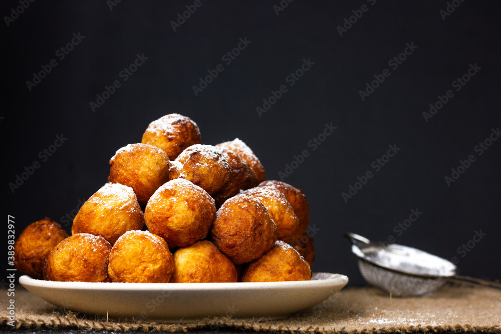 Round homemade donuts in a plate on a wooden table