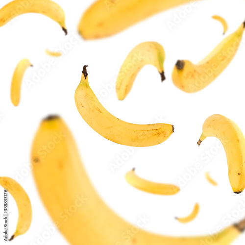 Many bananas free falling on white background. Selective focus - shallow depth of field.