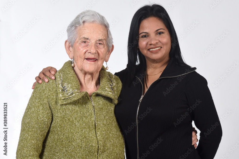 South American girl caring for an old woman on white background South American girl caring for an old woman on white background