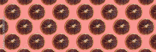 Banner with dried orange slices pattern on a coral background. Monochromatic composition.
