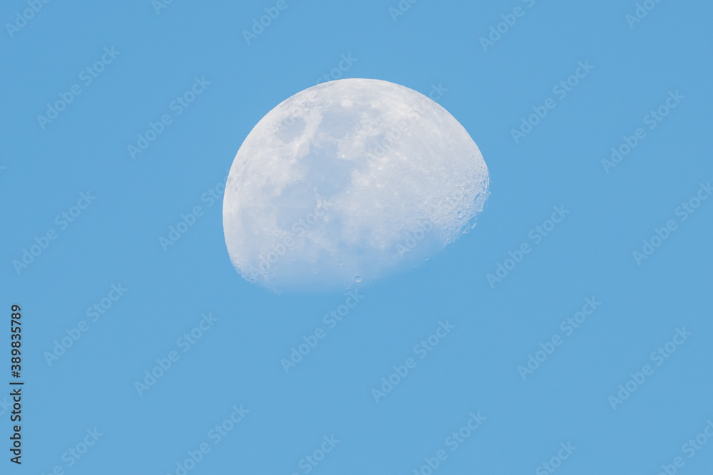 Three quarter daytime Moon in blue sky Three quarter daytime Moon in blue sky