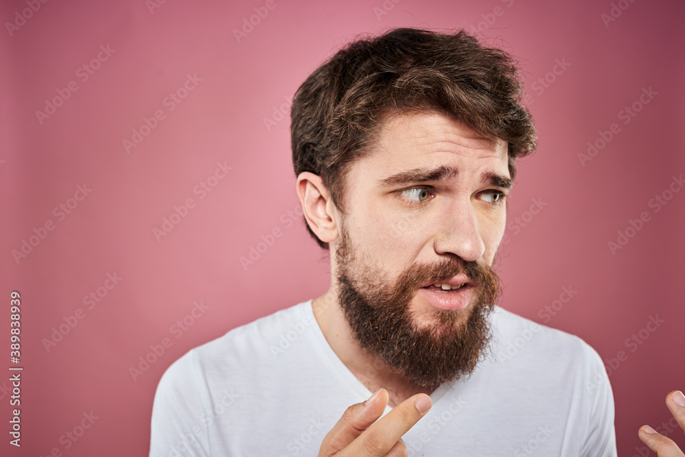 Fototapeta premium bearded man in white t-shirt emotions displeased facial expression studio pink background
