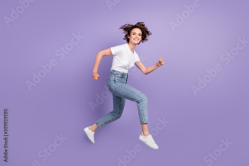 Full length body size side profile photo of girl jumping high hurrying up on sale smiling isolated on bright violet color background