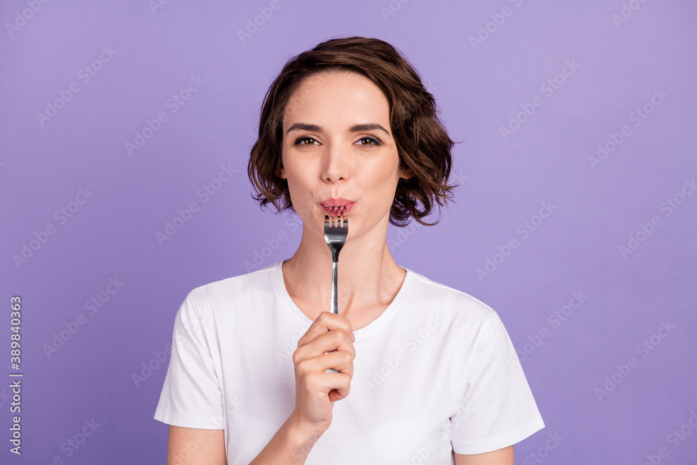 Portrait photo of slimming girl licking fork hungry diet wearing white t-shirt isolated on vibrant violet color background Portrait photo of slimming girl licking fork hungry diet wearing white t-shirt isolated on vibrant violet color background