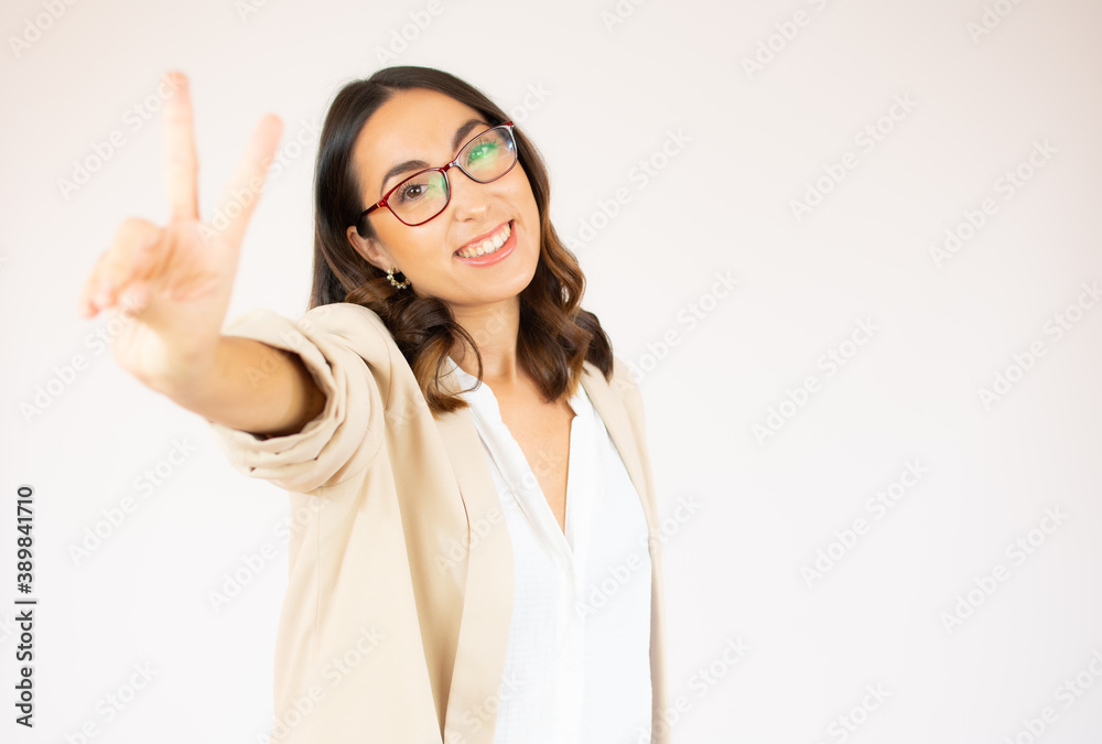 Portrait of a smiling happy woman showing victory sign and looking at camera isolated on the white background Portrait of a smiling happy woman showing victory sign and looking at camera isolated on the white background