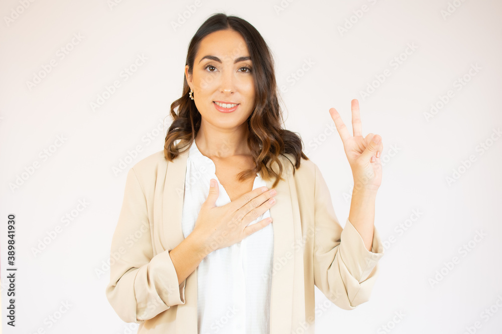 Portrait of a smiling happy woman showing victory sign and looking at camera isolated on the white background Portrait of a smiling happy woman showing victory sign and looking at camera isolated on the white background